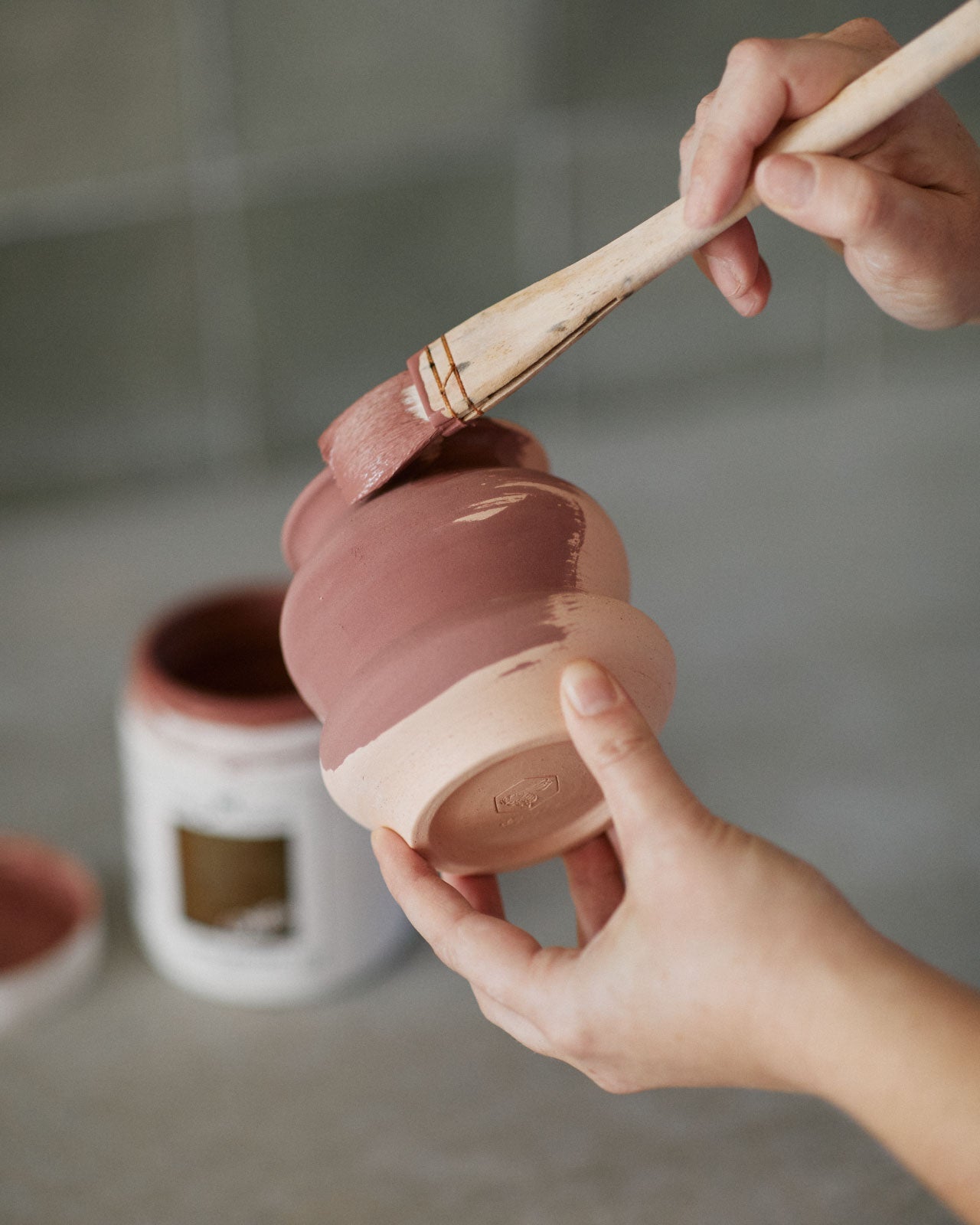 Students glazing their first wheel-thrown pieces