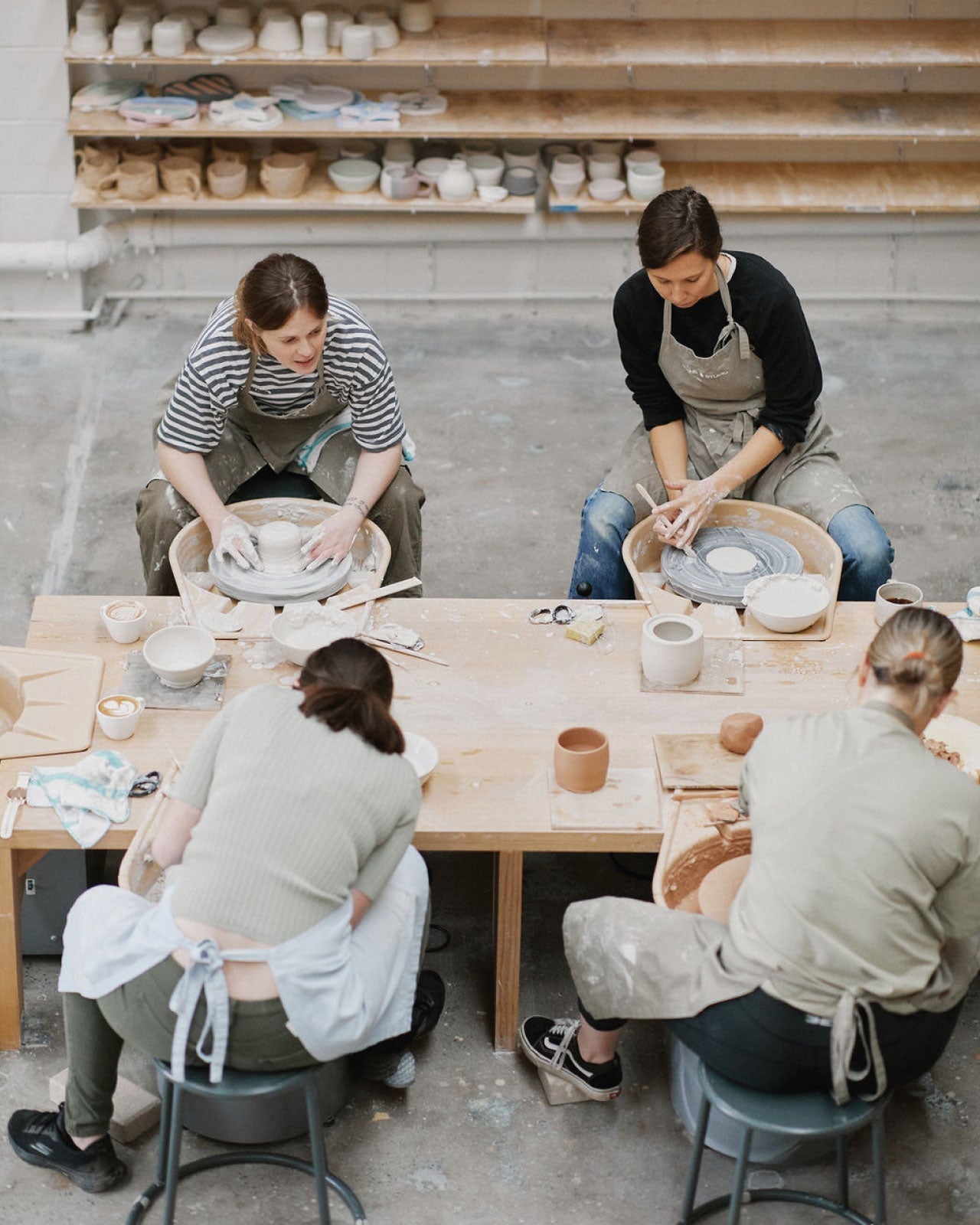 Students throwing larger forms on pottery wheel