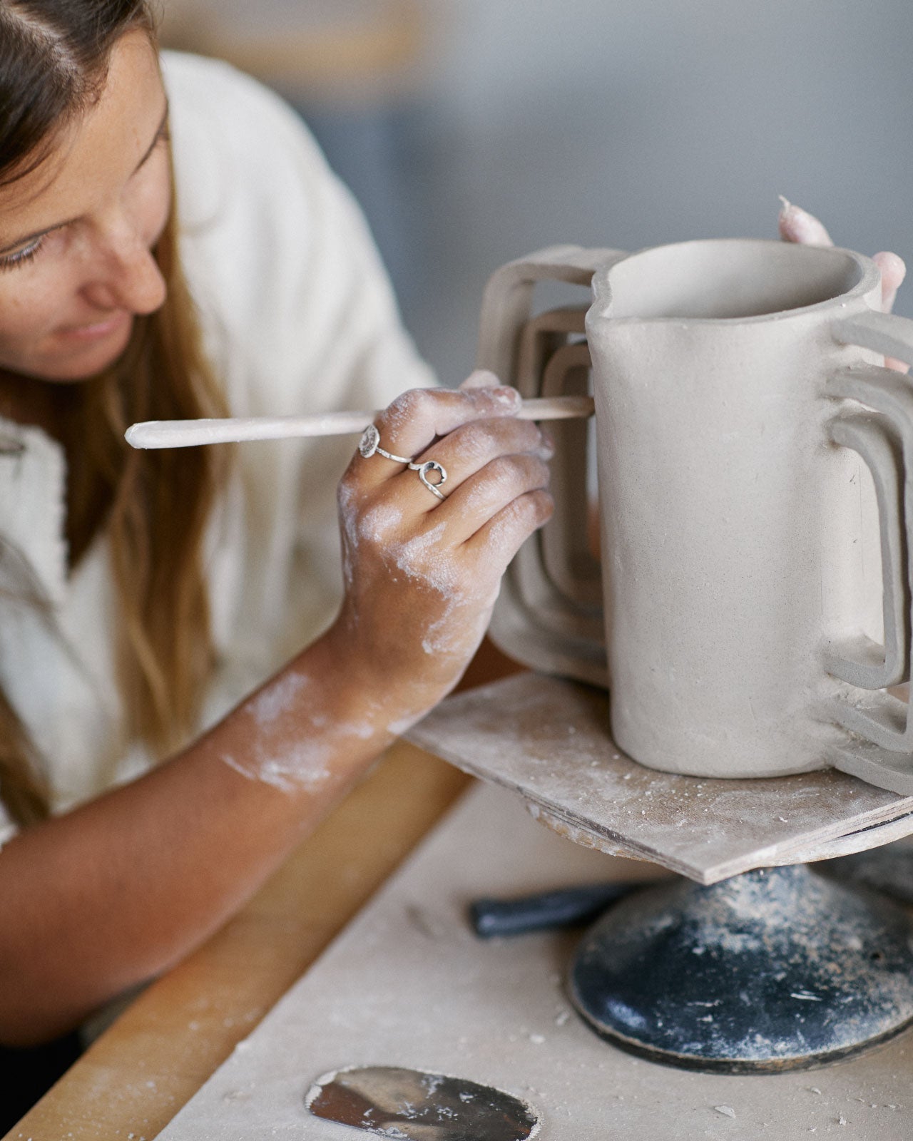 Instructor reviewing hand-built ceramic pieces