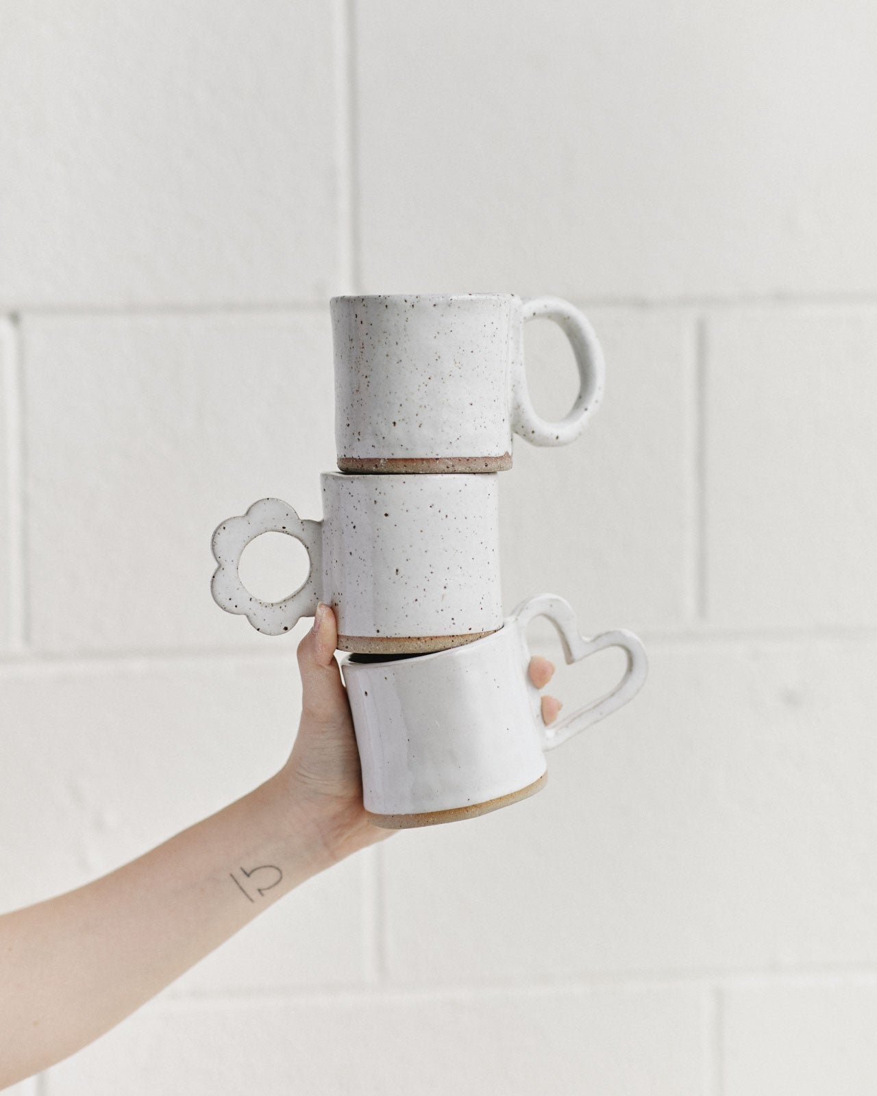 Student attaching handle to handmade ceramic mug