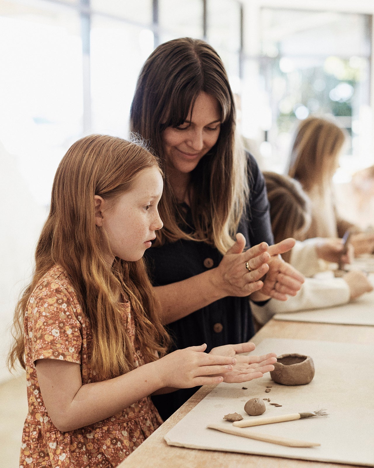 Families painting designs on their handmade mugs