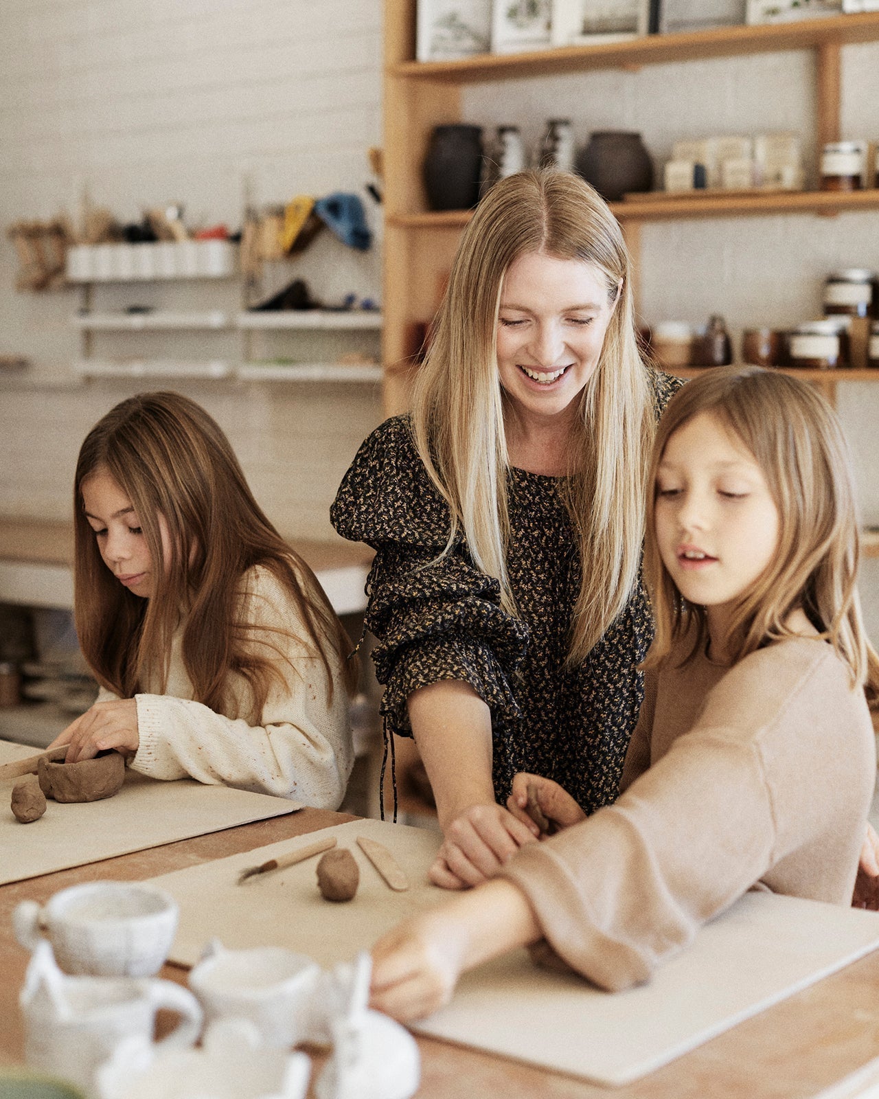 Parent guiding child's hands on pottery wheel