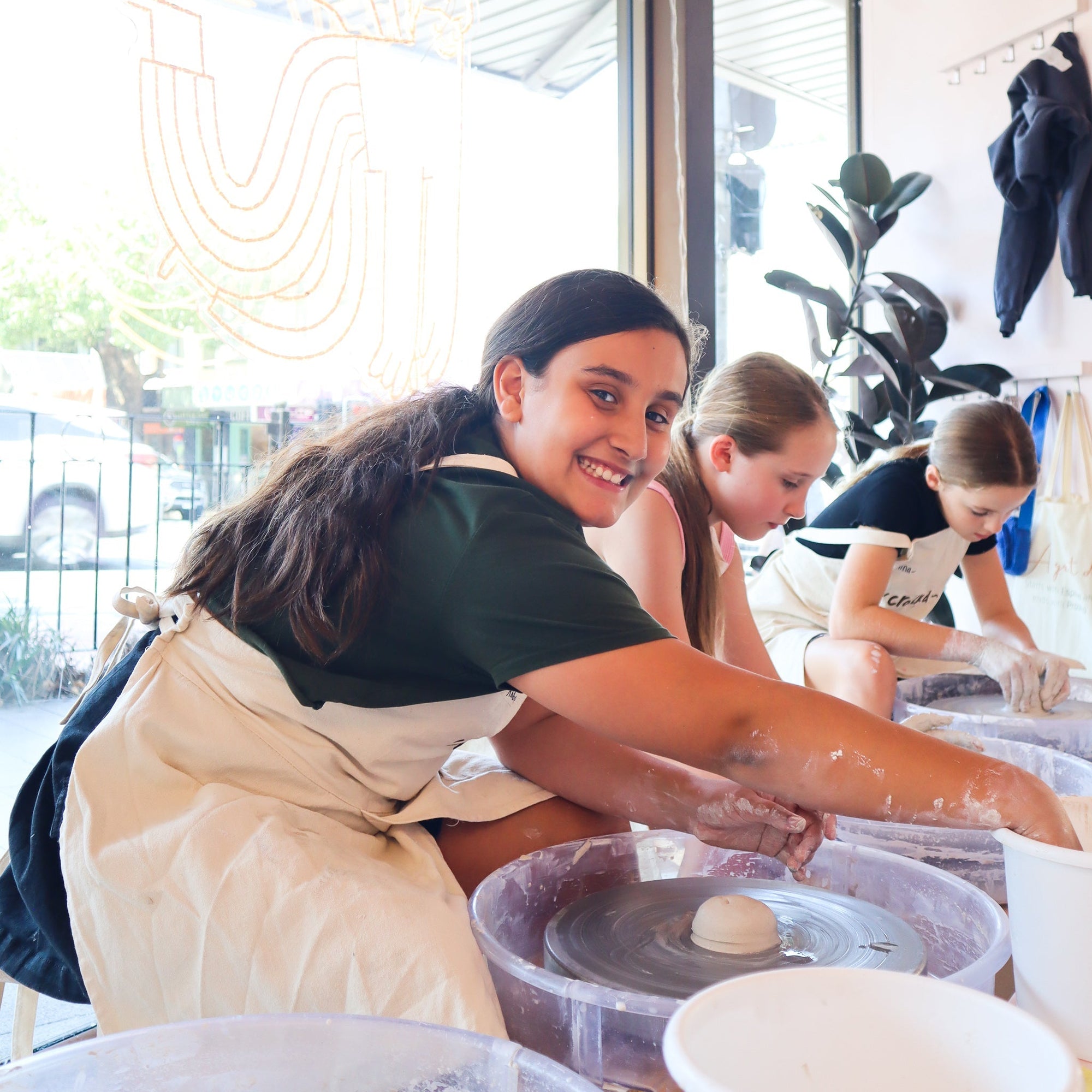 Kids glazing their ceramic creations during holiday class