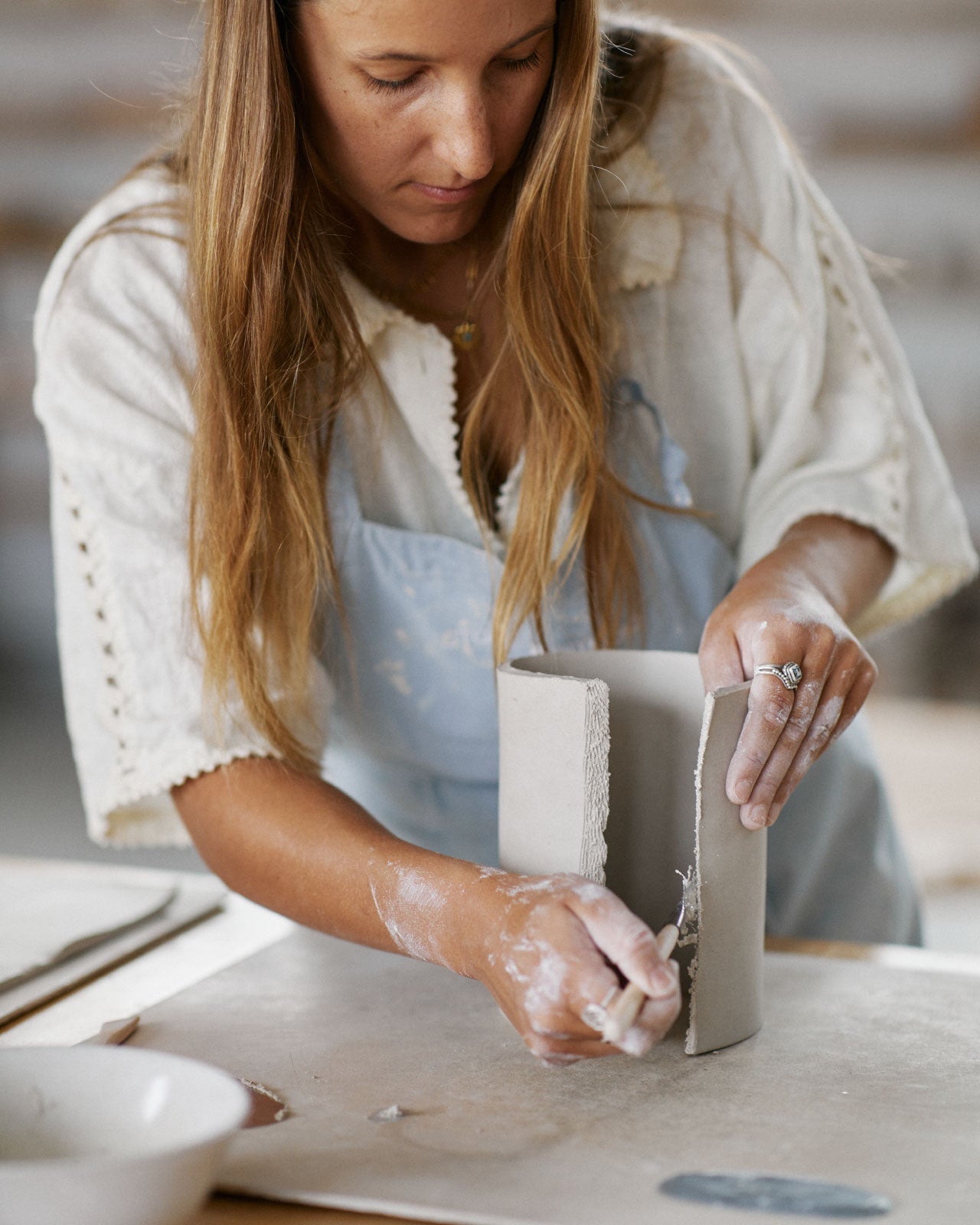 Students shaping clay into vase forms