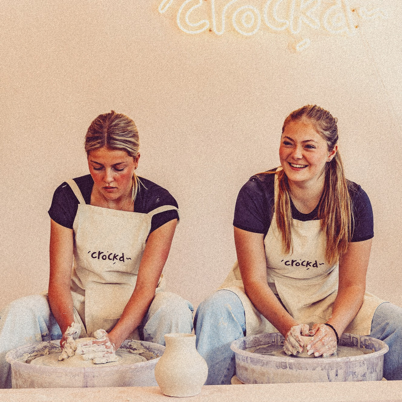 Student centering clay on pottery wheel