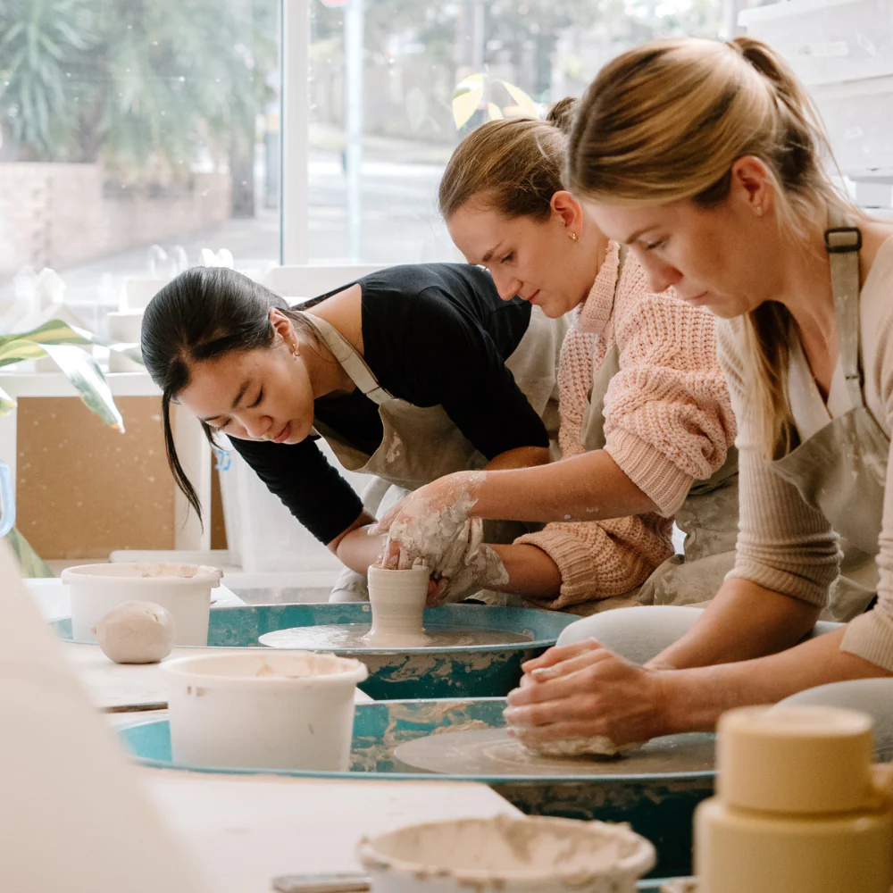 Participants with their first wheel-thrown pieces