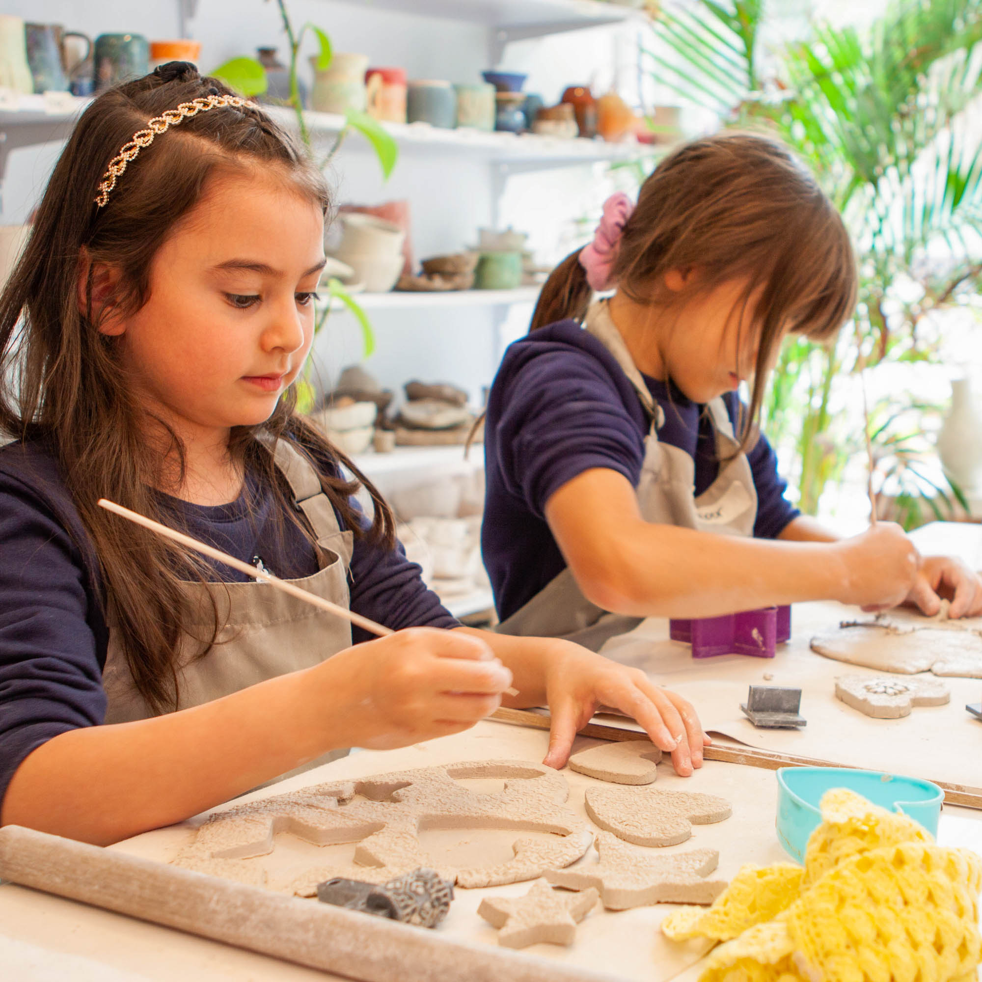 Instructor demonstrating clay techniques to families