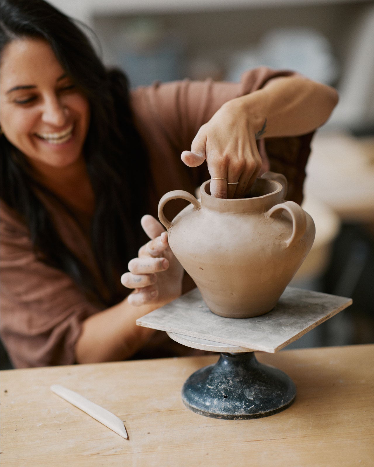 Friends creating ceramic vases while enjoying wine