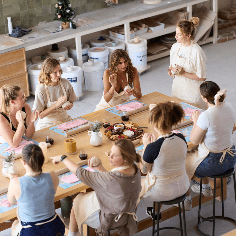 People making and painting handmade ceramic Christmas ornaments during a pottery workshop.