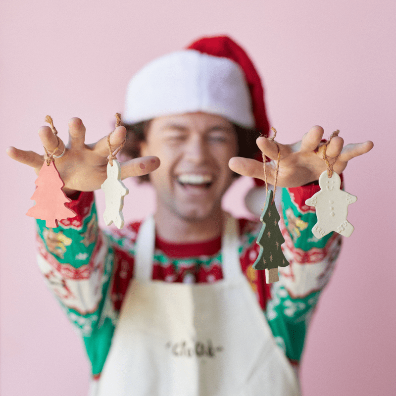 People making and painting handmade ceramic Christmas ornaments during a pottery workshop.