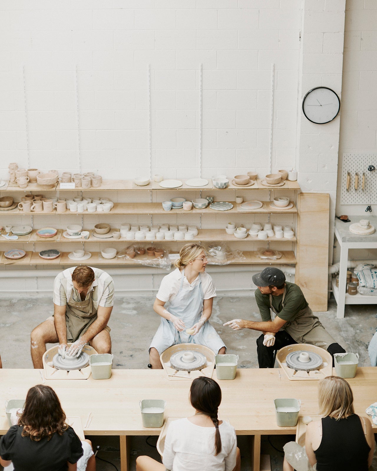 Pairs enjoying wine while hand-building clay pieces